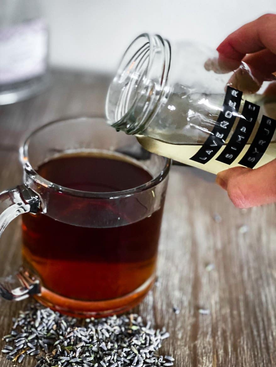 Lavender syrup for coffee being poured into cup.