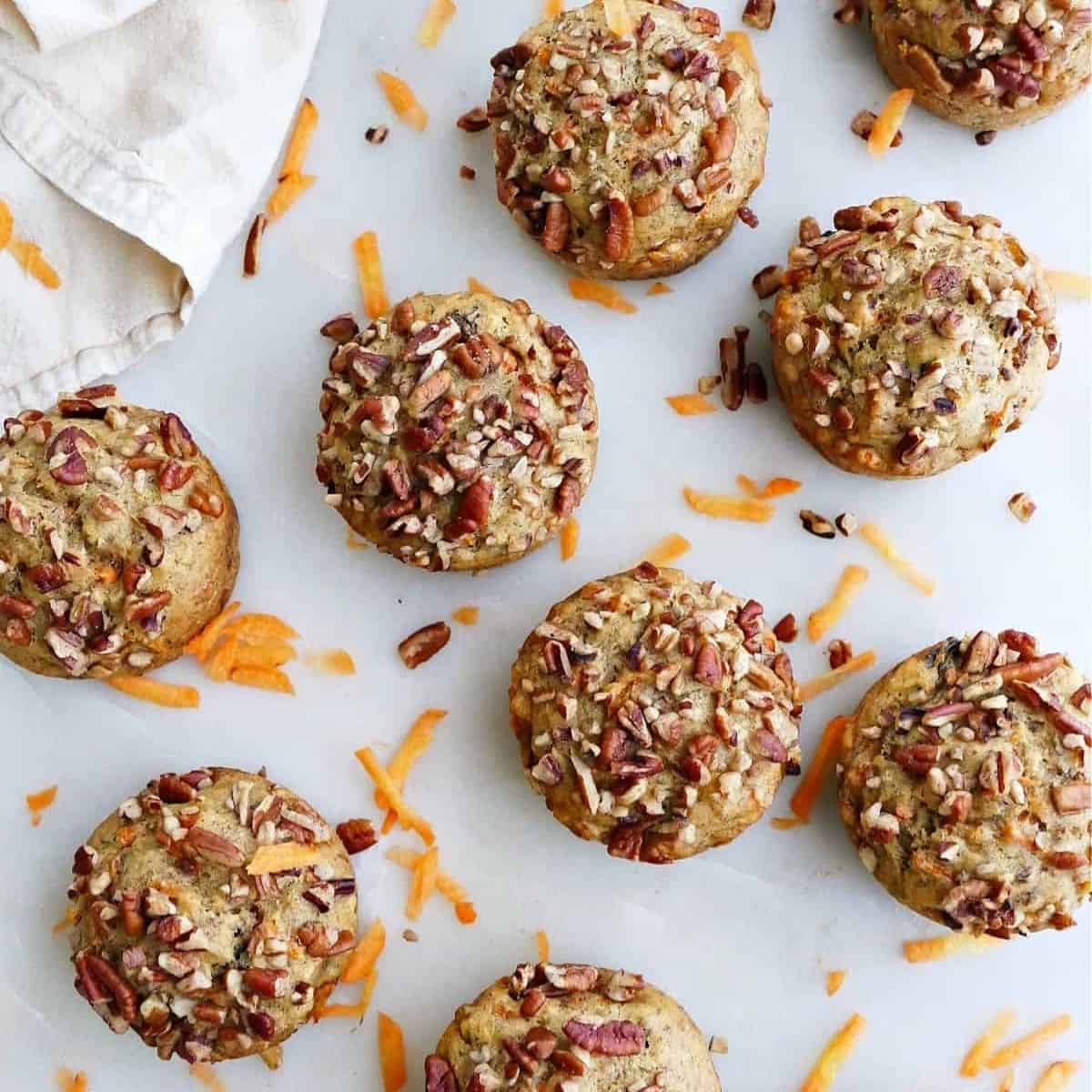 top down view of vegan banana and carrot muffins. Topped with pecans. 