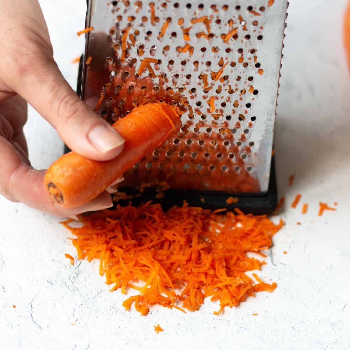 shredding carrots on a box grater