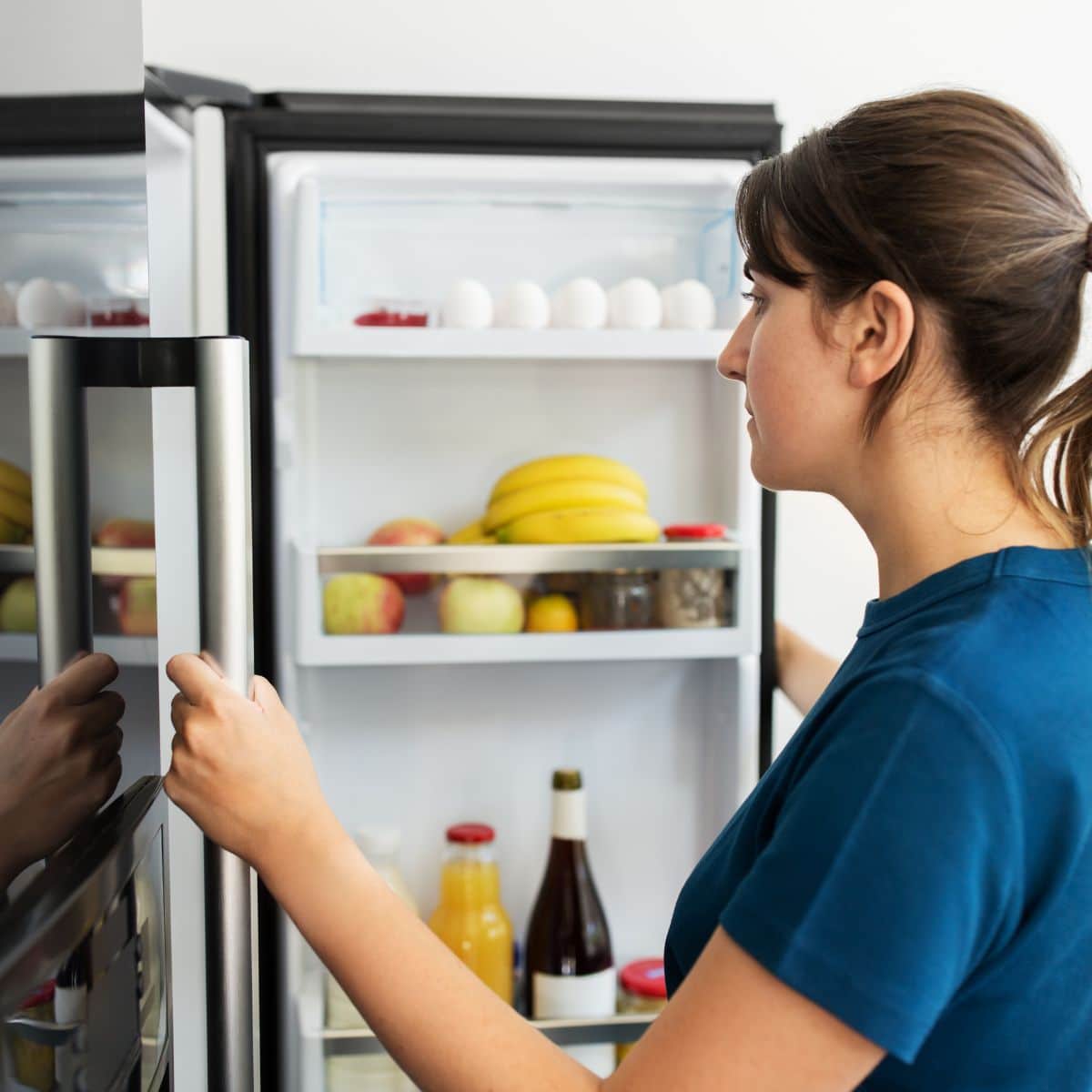 Image of woman looking in refrigerator for food.