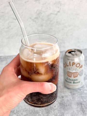 hand holding a glass of a prebiotic drink
