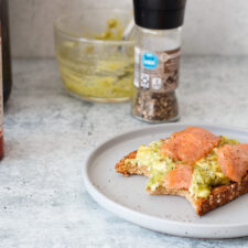 smoked salmon and egg on toast with avocado on a plate