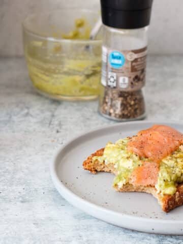smoked salmon and egg on toast with avocado on a plate