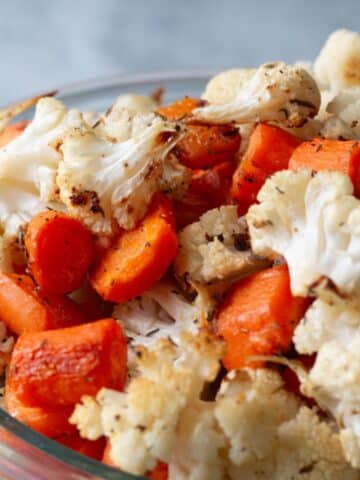 up close image of roasted carrots and cauliflower in a bowl