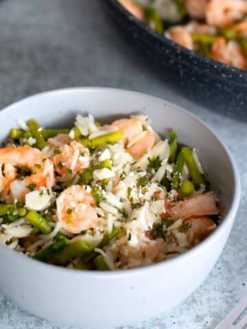 Lemon garlic rice bowl with shrimp and asparagus served in a white bowl, featuring tender shrimp, vibrant asparagus, and fragrant rice with a zesty garlic lemon touch.