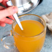 A clear glass of homemade Starbucks Medicine Ball tea made with lemonade, green tea with peach, and peppermint tea.