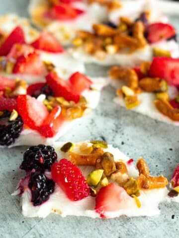 Frozen Greek Yogurt Bark with Berries topped with blueberries, strawberries, and crushed pretzels for a sweet, crunchy, quick high-protein snack.