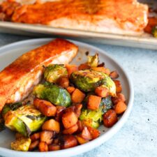 Sheet Pan Salmon with Veggies served on a plate with roasted butternut squash and Brussels sprouts—a nutritious, practical, and flavorful one-pan meal.