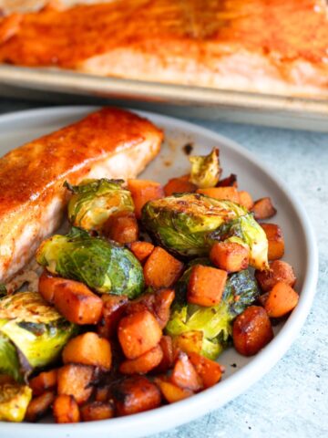 Sheet Pan Salmon with Veggies served on a plate with roasted butternut squash and Brussels sprouts—a nutritious, practical, and flavorful one-pan meal.