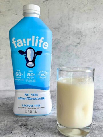 Fairlife ultra-filtered milk bottle beside a glass filled with milk. Is ultra-filtered milk healthy?