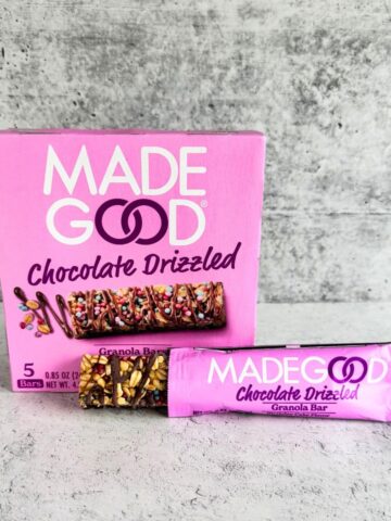 A box of Made Good Chocolate Drizzled granola bars with one wrapped bar and one unwrapped bar placed in front on a gray surface. Are made good bars healthy?