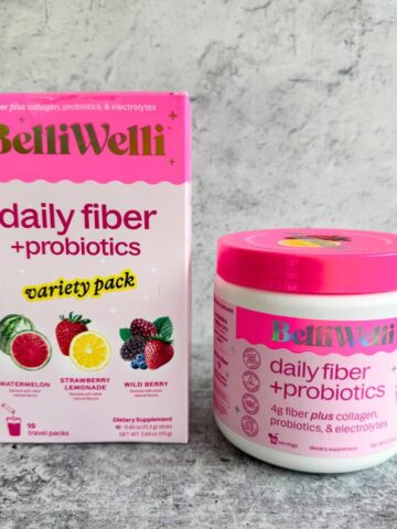 A box of Belliwelli Strawberry Lemonade Daily Fiber Supplement packs with a 6.3oz powder container placed on a table. Belliwelli review.